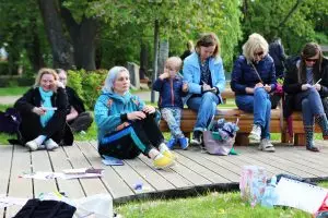 Kobieta siedząca na podeście, widoczne przybory do pisania